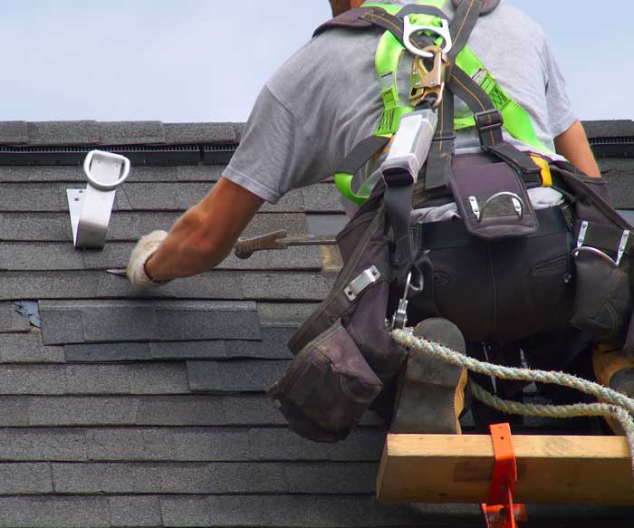 A roofing professional fixing a residential roof near Oakland Park, FL